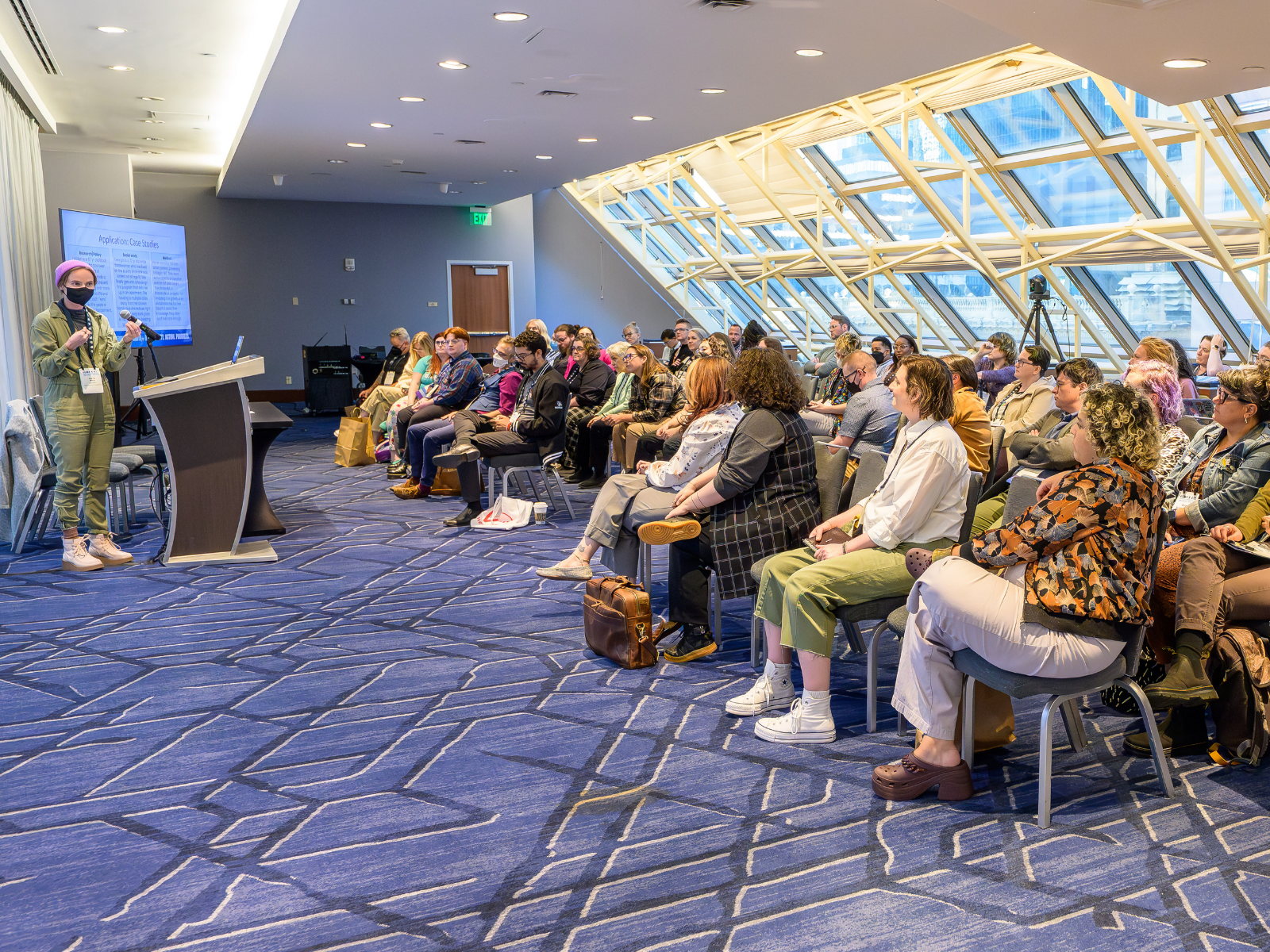 Workshop presenter and attendees in a conference room.